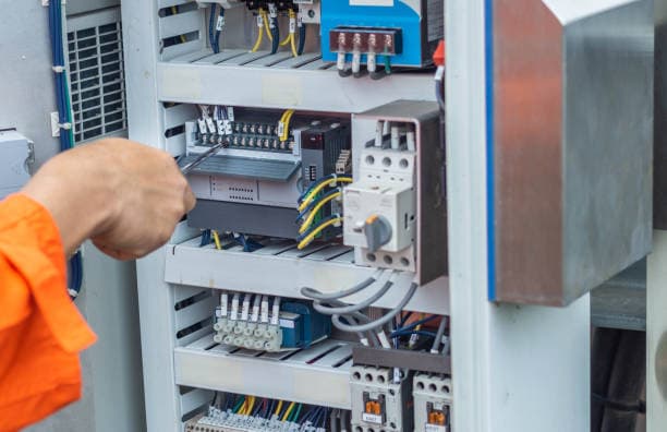 Techniker kontrolliert Leitungen, Steckdosen und Sicherungen zur normgerechten Abnahme in Berlin.