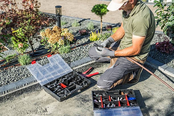 Fachmann montiert energieeffiziente Außenleuchten in einem privaten Gartenbereich in Berlin.
