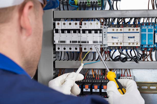 Fachtechniker wartet und erneuert elektrische Verteilungen in einer Hausinstallation in Berlin.